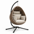 Fauteuil suspendu en résine tressée marron avec coussins crème et support en métal noir